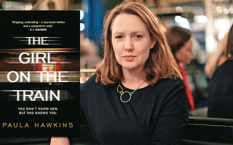 Paula Hawkins, autora de ‘La chica del tren’ junto a la portada de la novela. Foto: PULL