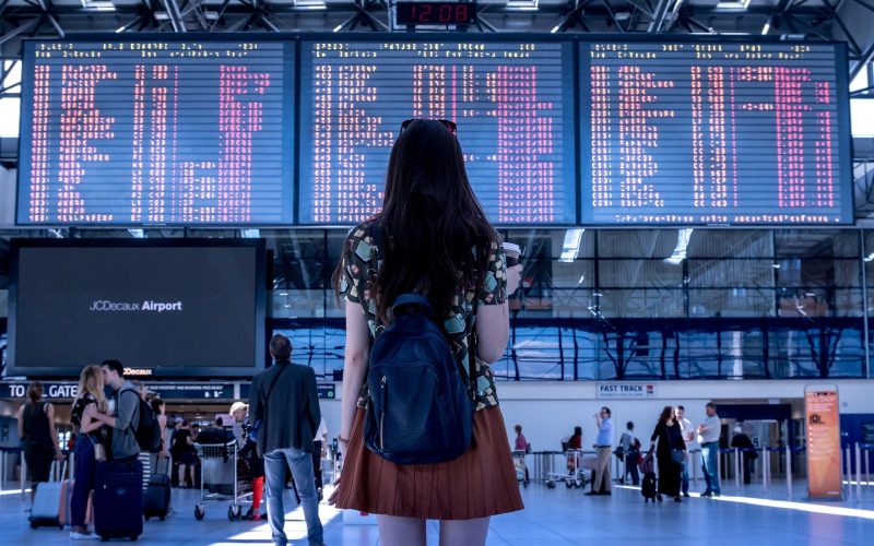 chica mirando paneles de vuelos de un aeropuerto